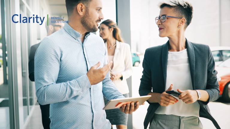 How Your Benefit Choices Shape the Employee Experience. Co-Workers in an office discussing employee benefits
